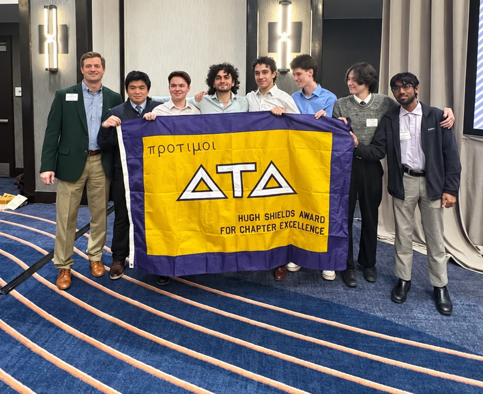 Gamma Beta brothers together with the chapter flag at the Hugh Shields awards celebration